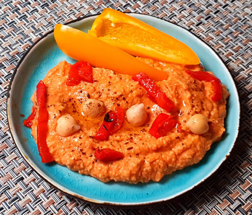 Hummus geroosterde paprika op een schaaltje