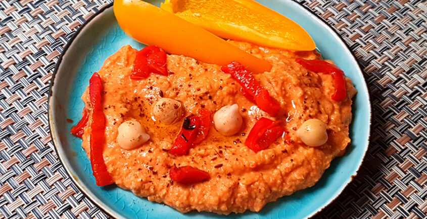 Hummus geroosterde paprika op een schaaltje