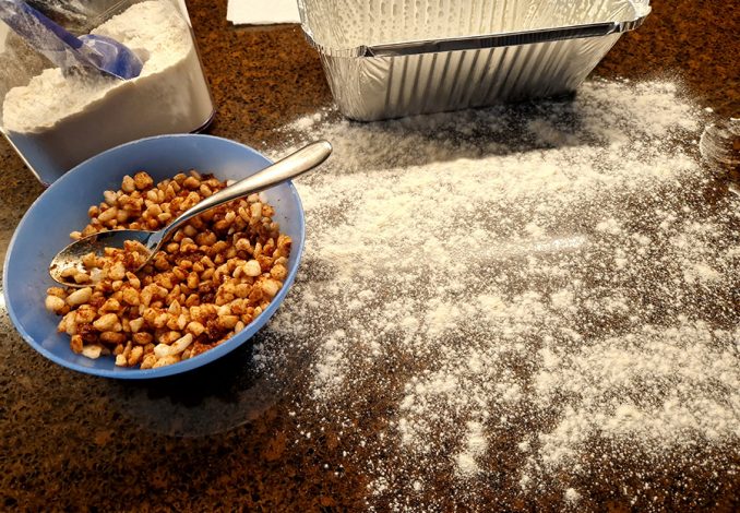 Fries suikerbrood, werkblad bebloemd en kom met parelsuiker vermengt met boter en kaneel.