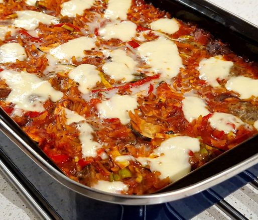 Orzo met tomaat en gehakt in een ovenschaal.